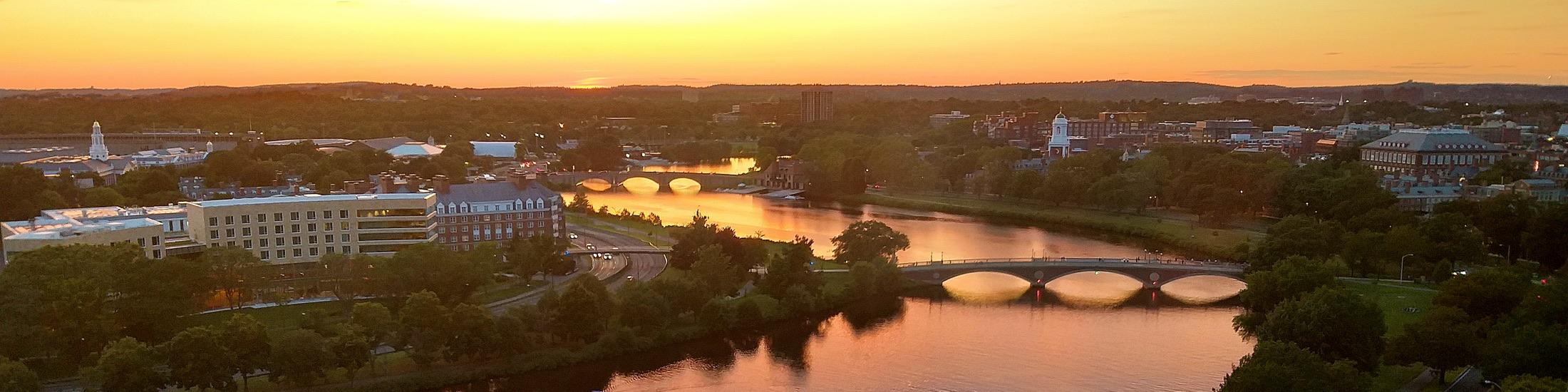 Harvard and Cambridge skyline over the Charles River at sunset