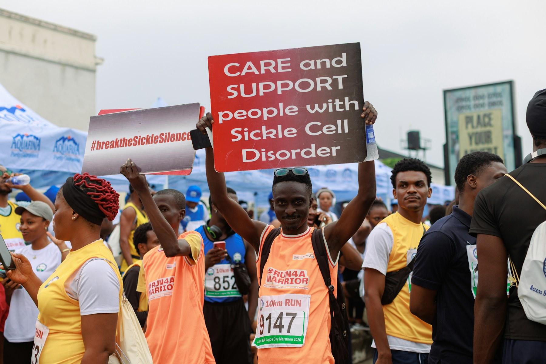 People holding signs for sickle cell disorder awareness
